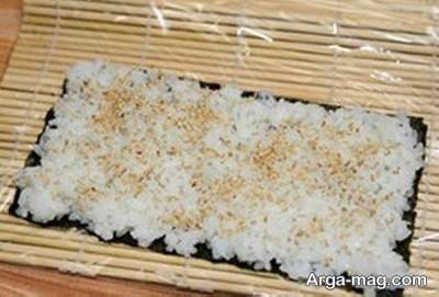 ریختن برنج و کنجد روی جلبک 