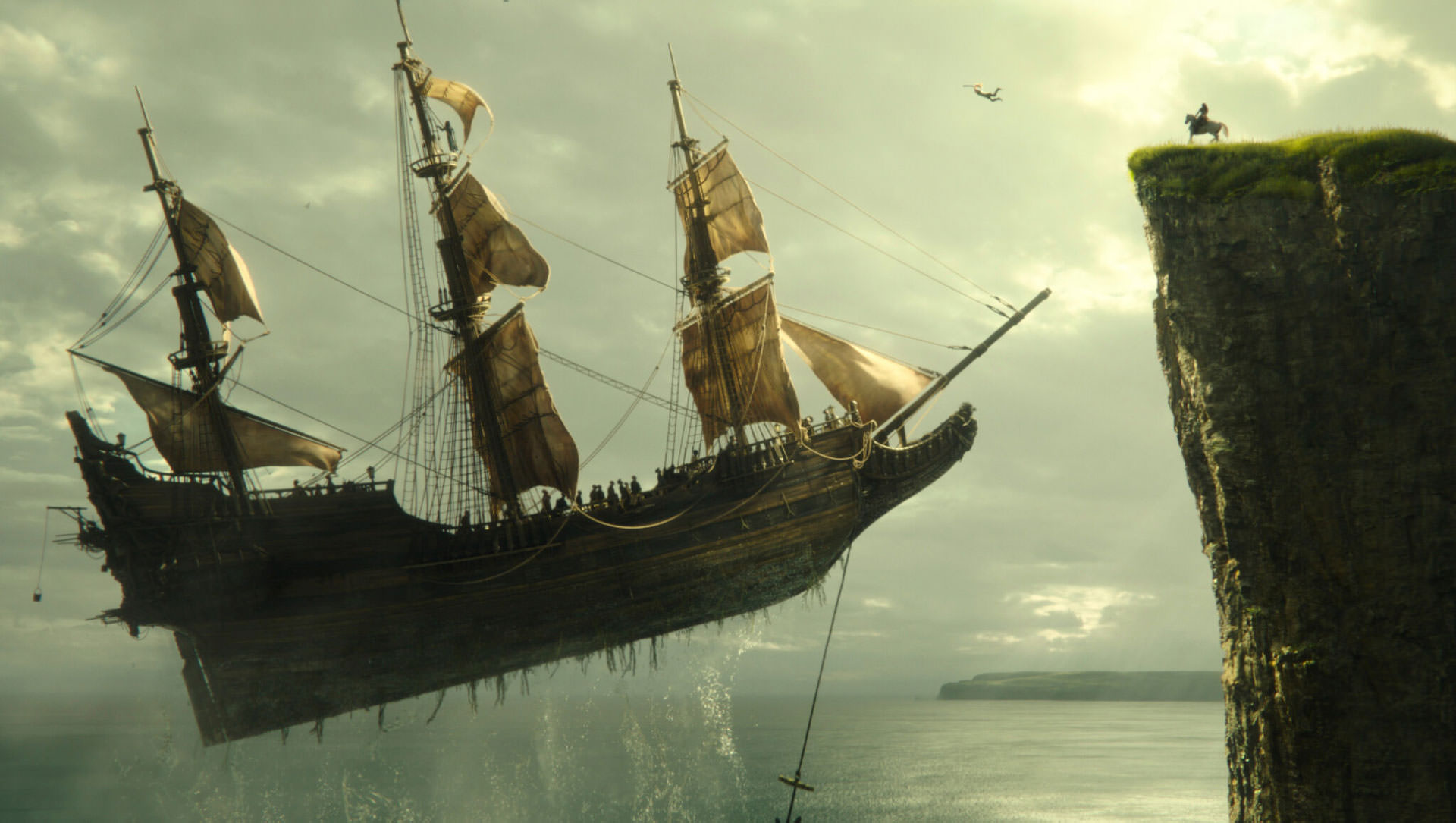 یک کشتی قدیمی در حال بلند شدن از زمین مقابل یک صخره در نمایی از فیلم پیتر پن و وندی به کارگردانی دیوید لاوری