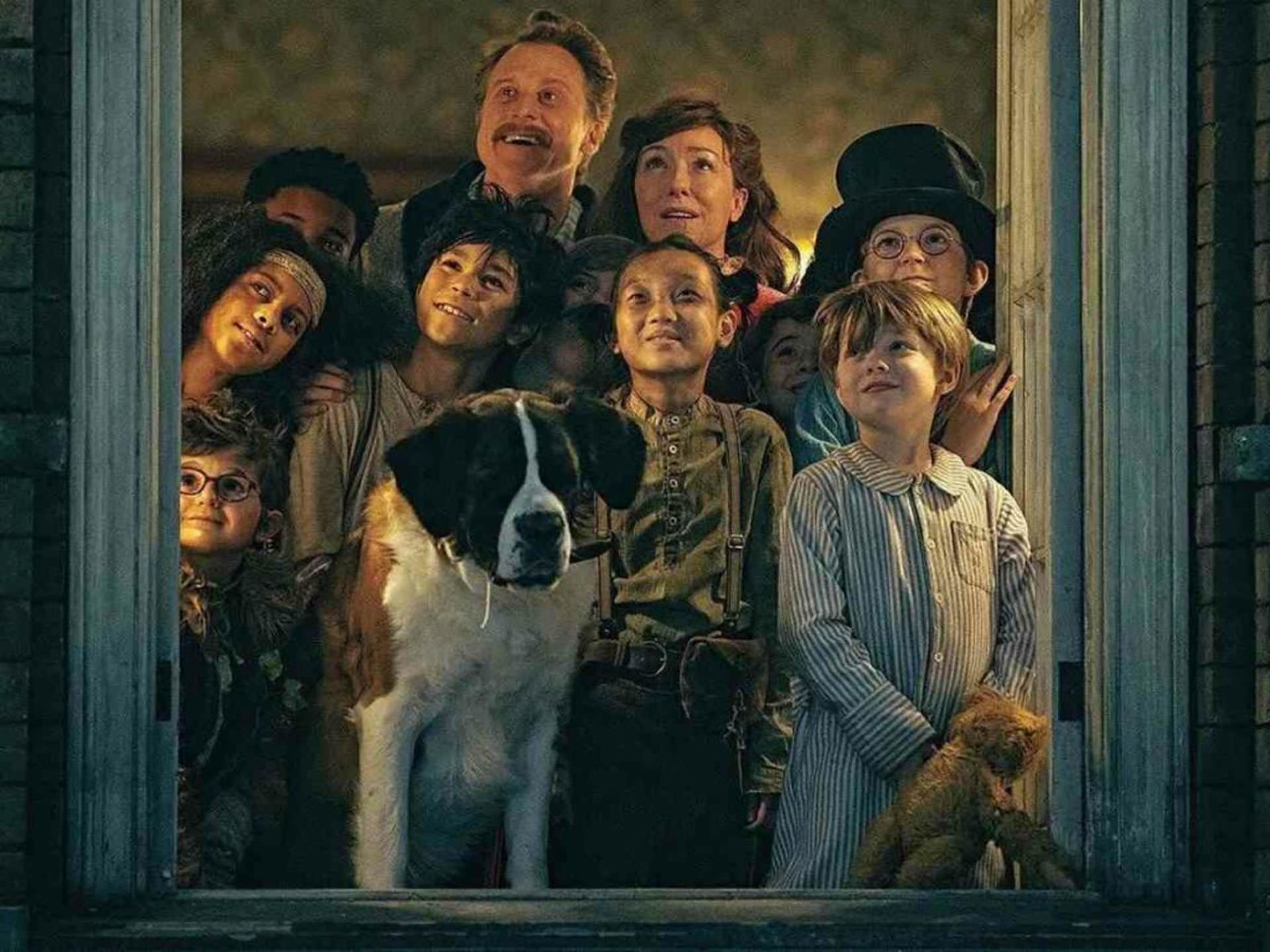 یک خانواده و یک سگ در حال تماشای آسمان بیرون از یک پنجره در نمایی از فیلم پیتر پن و وندی به کارگردانی دیوید لاوری